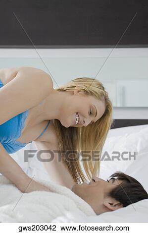 Young couple romancing on the bed View Large Photo Image Stock Image - Young couple romancing on the bed. Fotosearch