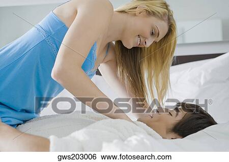 Young couple romancing on the bed View Large Photo Image Stock Photograph - Young couple romancing on the bed. Fotosearch