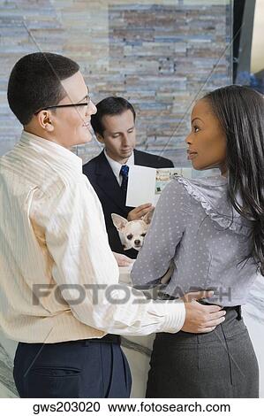 Young couple standing at the reception with a puppy View Large Photo Image Stock Image - Young couple standing at the reception with a puppy. Fotosearch