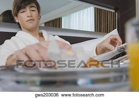 Young man having breakfast View Large Photo Image Stock Photograph - Young man having breakfast. Fotosearch