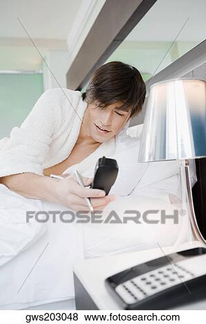 Stock Photo - Young man holding a cordless phone. Fotosearch