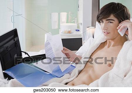 Young man talking on a mobile phone View Large Photo Image Stock Image - Young man talking on a mobile phone. Fotosearch