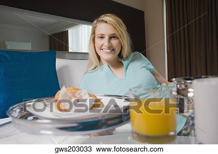 Young woman having breakfast on the bed View Large Photo Image Stock Image - Young woman having breakfast on the bed. Fotosearch