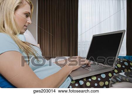 Young woman working on a laptop View Large Photo Image Picture - Young woman working on a laptop. Fotosearch