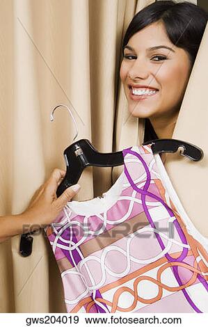 Close-up of a sales clerk's hand giving a dress to a young woman View Large Photo Image Stock Photo - Close-up of a sales clerk's hand giving a dress to a young woman. Fotosearch