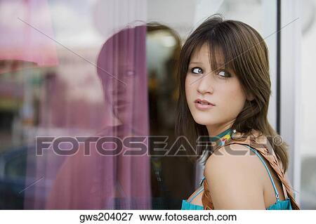 Side profile of a young woman window shopping View Large Photo Image Stock Photo - Side profile of a young woman window shopping. Fotosearch
