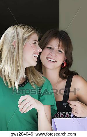Two young women holding shopping bags and smiling View Large Photo Image Stock Photograph - Two young women holding shopping bags and smiling. Fotosearch