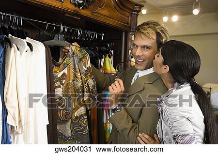Young woman kissing a mid adult man in a clothing store View Large Photo Image Stock Image - Young woman kissing a mid adult man in a clothing store. Fotosearch