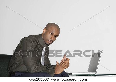 Stock Photo - Portrait of a businessman using a laptop. Fotosearch