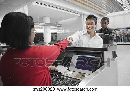 Businessman shaking hands with an airline check-in attendant View Large Photo Image Stock Image - Businessman shaking hands with an airline check-in attendant. Fotosearch