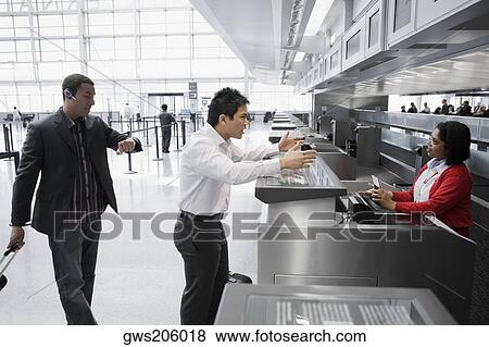Stock Photo - Businessman shouting at an airline check-in attendant. Fotosearch