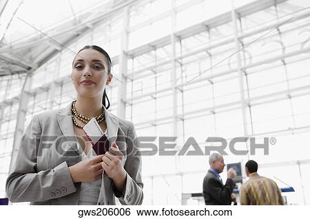 Businesswoman putting a passport with an airplane ticket in her coat's pocket View Large Photo Image Stock Photograph - Businesswoman putting a passport with an airplane ticket in her coat's pocket. Fotosearch