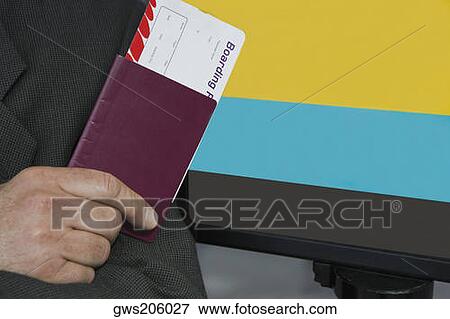Close-up of a businessman's hand holding a passport with an airplane ticket View Large Photo Image Stock Photo - Close-up of a businessman's hand holding a passport with an airplane ticket. Fotosearch