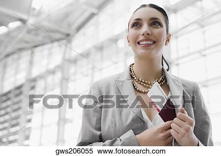 Close-up of a businesswoman putting a passport with an airplane ticket in her coat's pocket View Large Photo Image Stock Photography - Close-up of a businesswoman putting a passport with an airplane ticket in her coat's pocket. Fotosearch