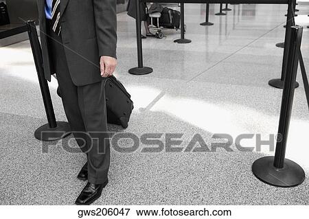 Low section view of a businessman pulling his luggage View Large Photo Image Stock Photo - Low section view of a businessman pulling his luggage. Fotosearch