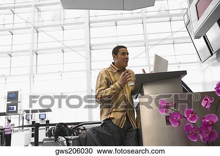 Mid adult man with a laptop looking surprised at an airport View Large Photo Image Stock Image - Mid adult man with a laptop looking surprised at an airport. Fotosearch