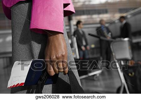 Mid section view of a businesswoman holding a passport with an airplane ticket View Large Photo Image Stock Photo - Mid section view of a businesswoman holding a passport with an airplane ticket. Fotosearch