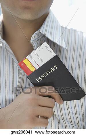 Mid section view of a young man putting a passport with an airplane ticket in his shirt's pocket View Large Photo Image Stock Image - Mid section view of a young man putting a passport with an airplane ticket in his shirt's pocket. Fotosearch