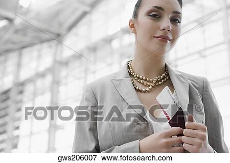 Portrait of a businesswoman putting a passport with an airplane ticket in her coat's pocket View Large Photo Image Stock Photo - Portrait of a businesswoman putting a passport with an airplane ticket in her coat's pocket. Fotosearch