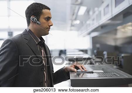 Side profile of a businessman standing at a ticket counter in an airport View Large Photo Image Stock Image - Side profile of a businessman standing at a ticket counter in an airport. Fotosearch
