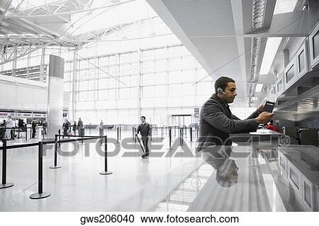 Side profile of a businessman standing at a ticket counter in an airport View Large Photo Image Stock Image - Side profile of a businessman standing at a ticket counter in an airport. Fotosearch