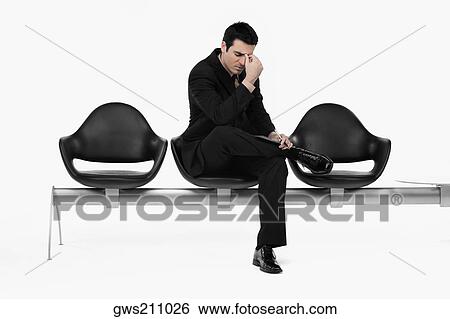 Stock Photograph - Businessman sitting on a bench and thinking. Fotosearch