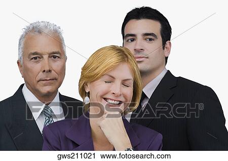 Close-up of a businesswoman smiling with two businessmen behind her View Large Photo Image Stock Image - Close-up of a businesswoman smiling with two businessmen behind her. Fotosearch
