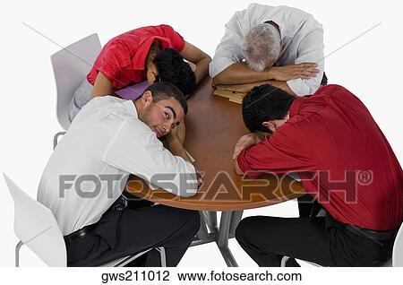 High angle view of three businessmen and a businesswoman resting their heads on a table View Large Photo Image Stock Image - High angle view of three businessmen and a businesswoman resting their heads on a table. Fotosearch