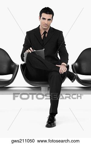 Portrait of a businessman sitting on a bench View Large Photo Image Stock Image - Portrait of a businessman sitting on a bench. Fotosearch