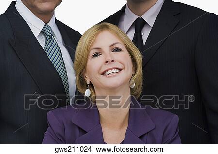 Portrait of a businesswoman smiling with two businessmen behind her View Large Photo Image Picture - Portrait of a businesswoman smiling with two businessmen behind her. Fotosearch