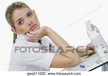 Stock Image - Side profile of a businesswoman with her hand on her chin. Fotosearch