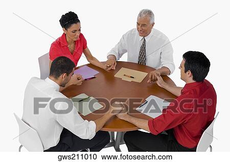 Three businessmen and a businesswoman praying with holding their hands in a meeting View Large Photo Image Stock Image - Three businessmen and a businesswoman praying with holding their hands in a meeting. Fotosearch