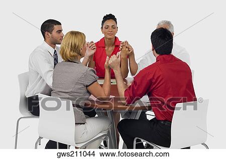 Three businessmen and two businesswomen praying with holding their hands in a meeting View Large Photo Image Picture - Three businessmen and two businesswomen praying with holding their hands in a meeting. Fotosearch