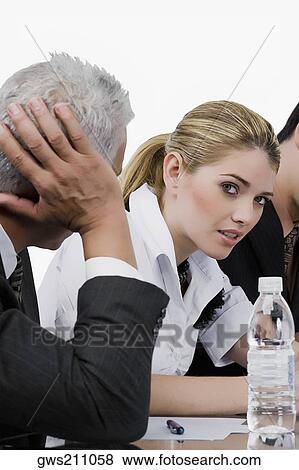 Two businessmen and a businesswoman at a meeting in a conference room View Large Photo Image Stock Photo - Two businessmen and a businesswoman at a meeting in a conference room. Fotosearch