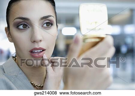 Close-up of a businesswoman checking her lips in a hand mirror View Large Photo Image Stock Photo - Close-up of a businesswoman checking her lips in a hand mirror. Fotosearch