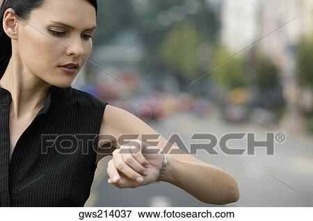 Close-up of a businesswoman checking the time View Large Photo Image Stock Photo - Close-up of a businesswoman checking the time. Fotosearch