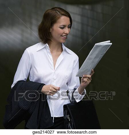 Stock Photo - Close-up of a businesswoman reading a newspaper and smiling. Fotosearch
