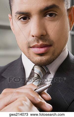 Portrait of a businessman holding a pen View Large Photo Image Stock Image - Portrait of a businessman holding a pen. Fotosearch