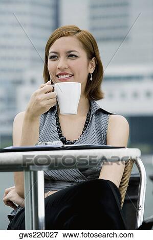Close-up of a businesswoman drinking coffee at a sidewalk cafe View Large Photo Image Stock Photo - Close-up of a businesswoman drinking coffee at a sidewalk cafe. Fotosearch