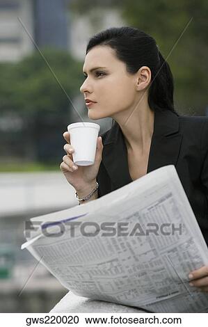 Close-up of a businesswoman holding a newspaper and thinking View Large Photo Image Stock Image - Close-up of a businesswoman holding a newspaper and thinking. Fotosearch