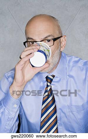 Stock Image - Portrait of a businessman having a drink. Fotosearch