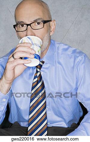 Portrait of a businessman having a drink View Large Photo Image Stock Photograph - Portrait of a businessman having a drink. Fotosearch