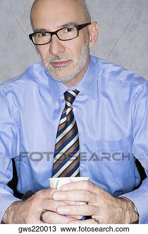 Portrait of a businessman holding a glass View Large Photo Image Stock Image - Portrait of a businessman holding a glass. Fotosearch