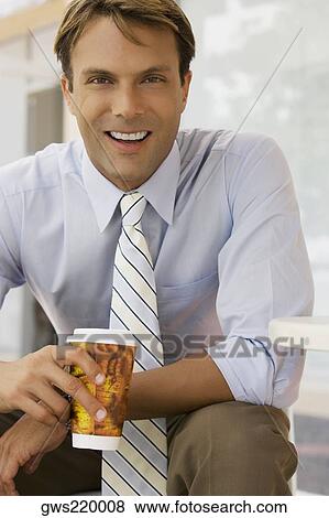 Stock Photo - Portrait of a businessman holding a coffee cup and smiling. Fotosearch