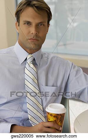 Portrait of a businessman holding a coffee cup in a cafe View Large Photo Image Stock Photography - Portrait of a businessman holding a coffee cup in a cafe. Fotosearch