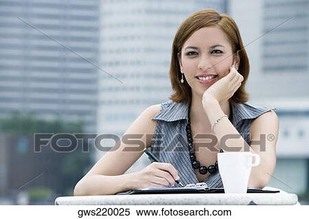 Stock Photography - Portrait of a businesswoman sitting at a sidewalk cafe. Fotosearch