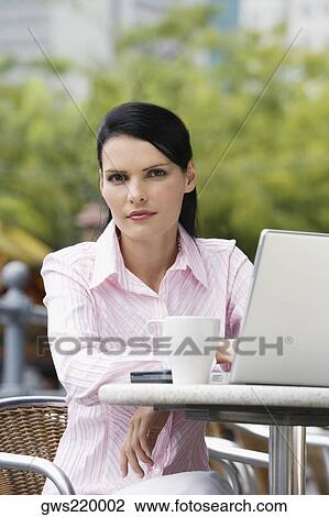 Portrait of a businesswoman sitting on a chair and using a laptop View Large Photo Image Stock Image - Portrait of a businesswoman sitting on a chair and using a laptop. Fotosearch