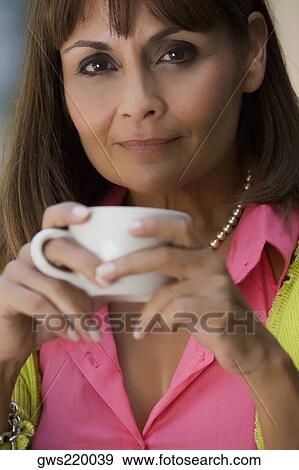 Portrait of a mature woman holding a cup of coffee View Large Photo Image Stock Photo - Portrait of a mature woman holding a cup of coffee. Fotosearch