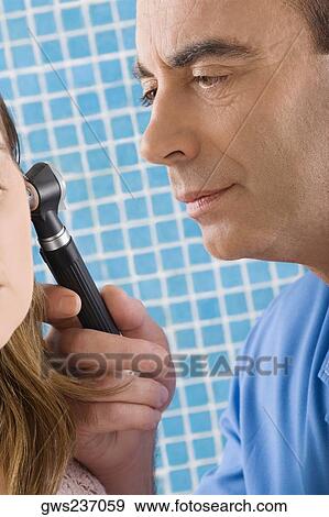 Close-up of a male doctor examining a mature woman's ear View Large Photo Image Stock Photo - Close-up of a male doctor examining a mature woman's ear. Fotosearch