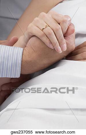 Close-up of a man's hand holding a female patient's hand View Large Photo Image Stock Photography - Close-up of a man's hand holding a female patient's hand. Fotosearch